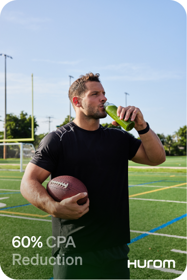 A man holding a football and a green drink.